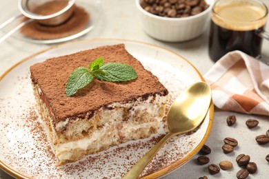 Photo of Piece of tasty tiramisu on beige table, closeup