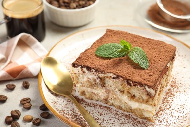 Photo of Piece of tasty tiramisu on beige table, closeup