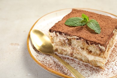 Photo of Piece of tasty tiramisu on beige table, closeup