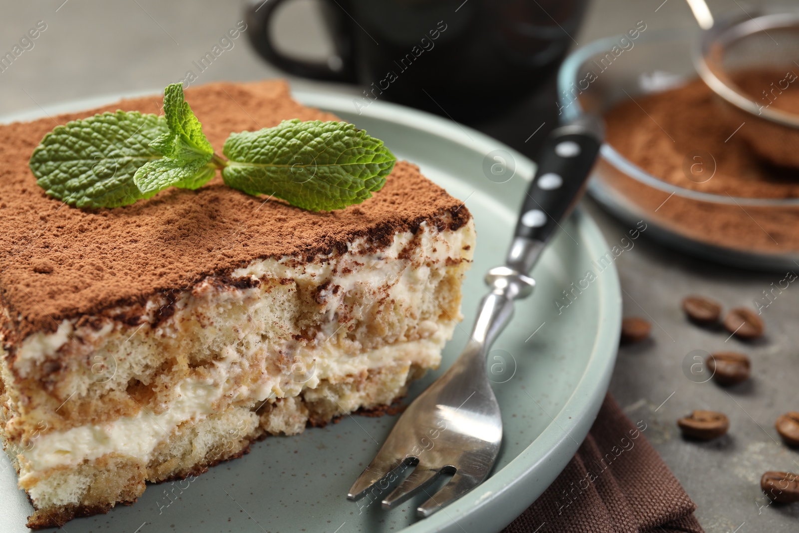 Photo of Piece of tasty tiramisu on grey table, closeup