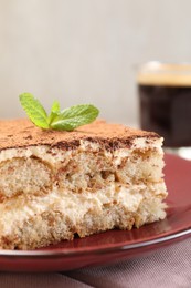 Photo of Delicious tiramisu with mint on table, closeup