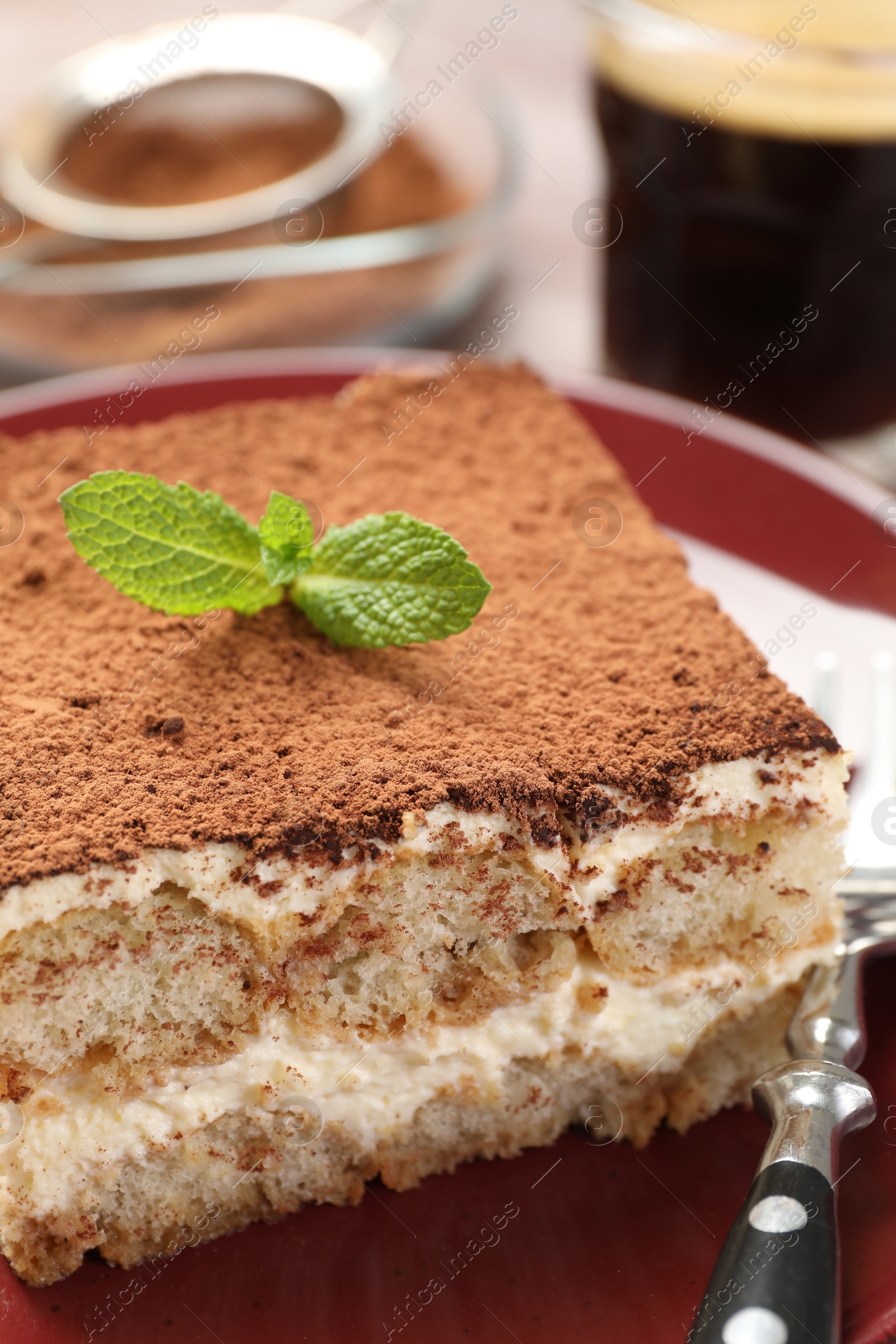 Photo of Delicious tiramisu with mint on table, closeup