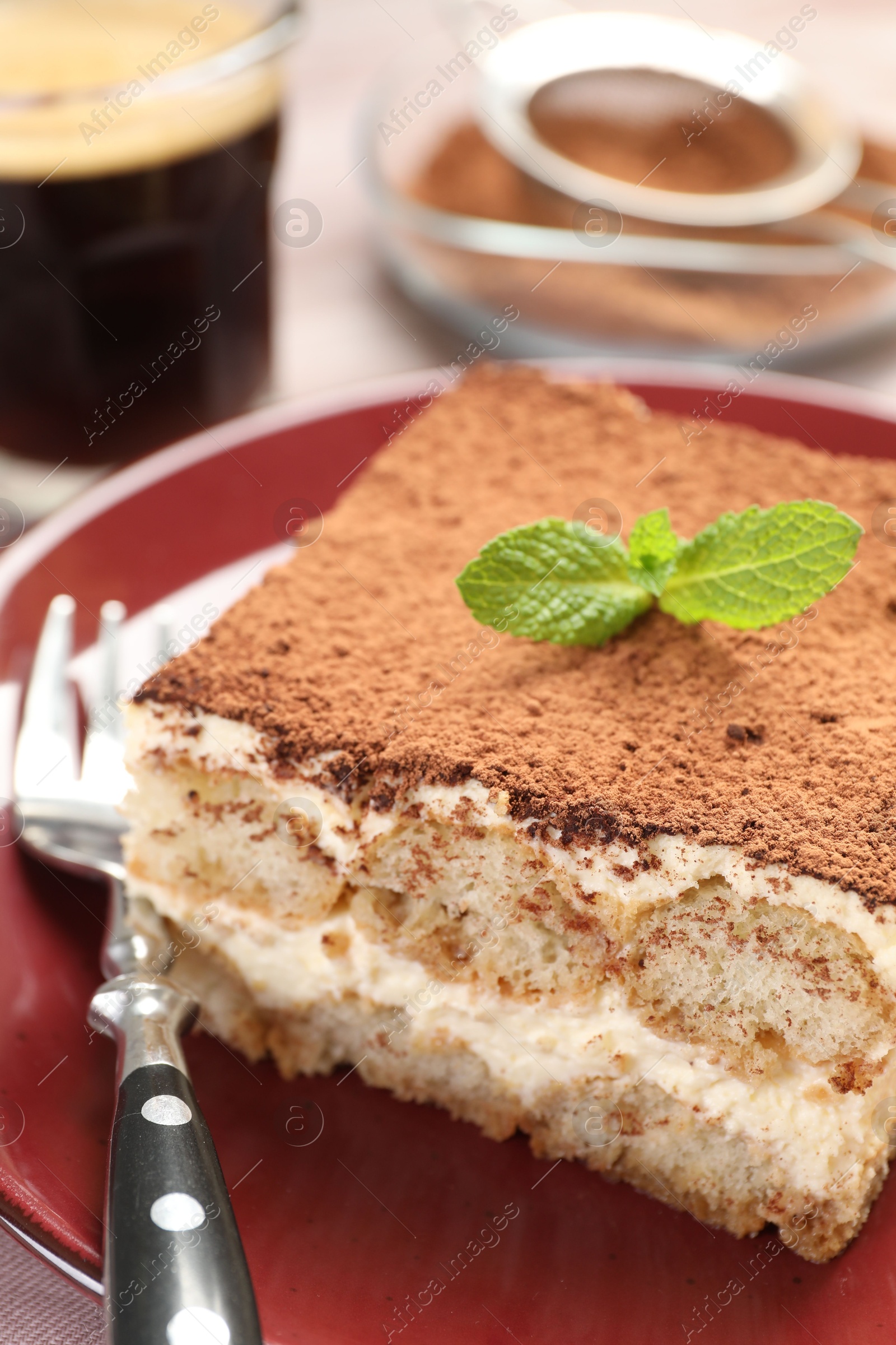 Photo of Delicious tiramisu with mint on table, closeup