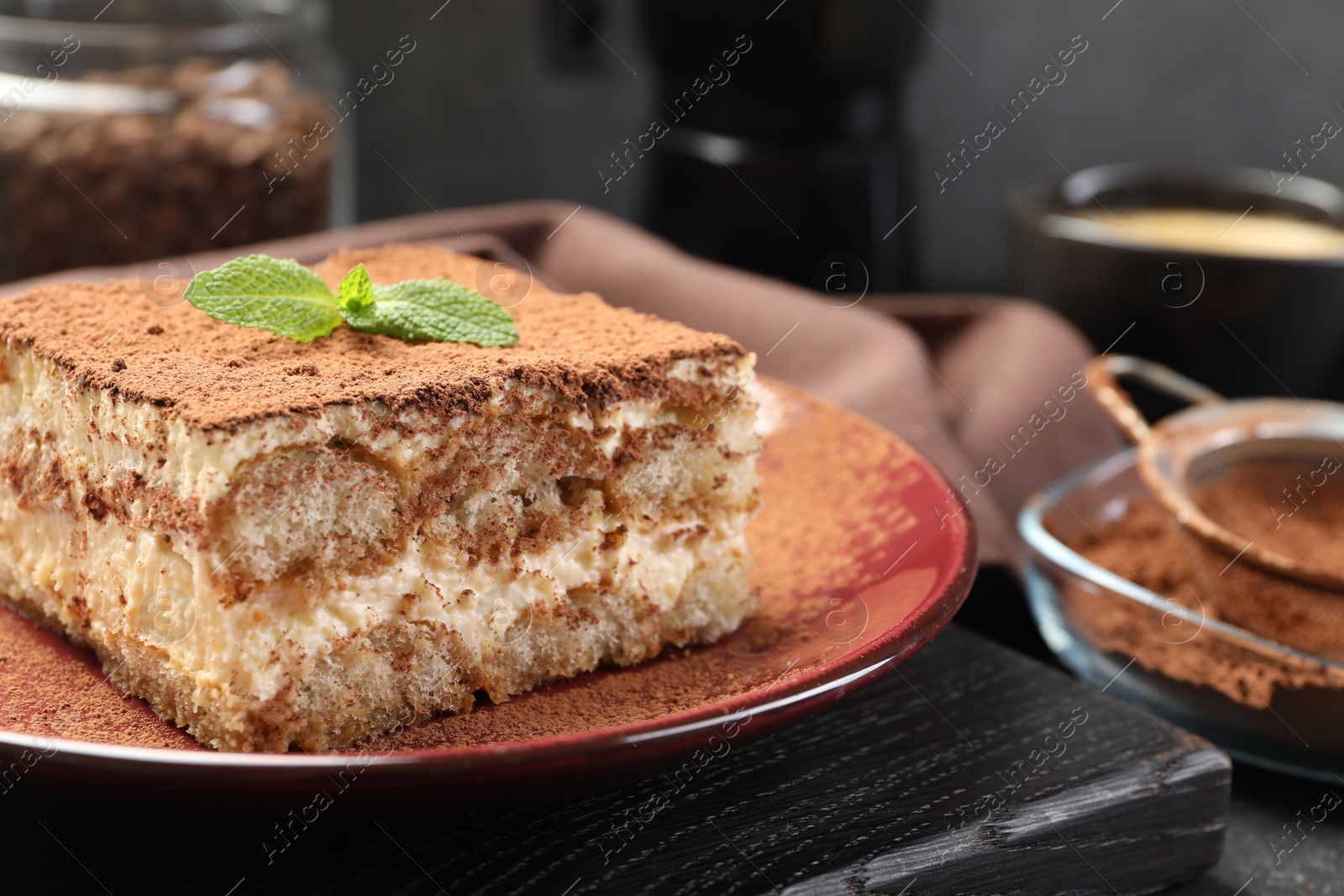 Photo of Delicious tiramisu with mint on table, closeup