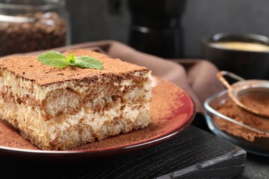 Photo of Delicious tiramisu with mint on table, closeup