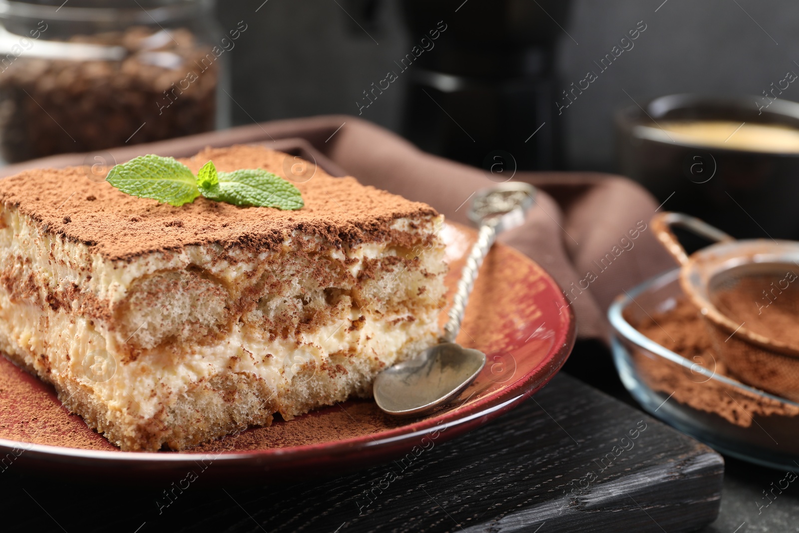 Photo of Delicious tiramisu with mint on table, closeup