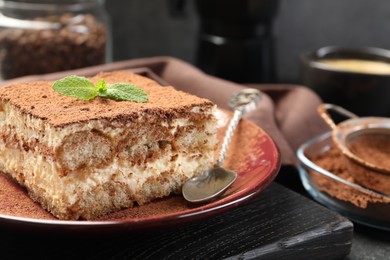 Photo of Delicious tiramisu with mint on table, closeup