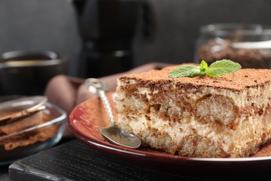 Photo of Delicious tiramisu with mint on table, closeup