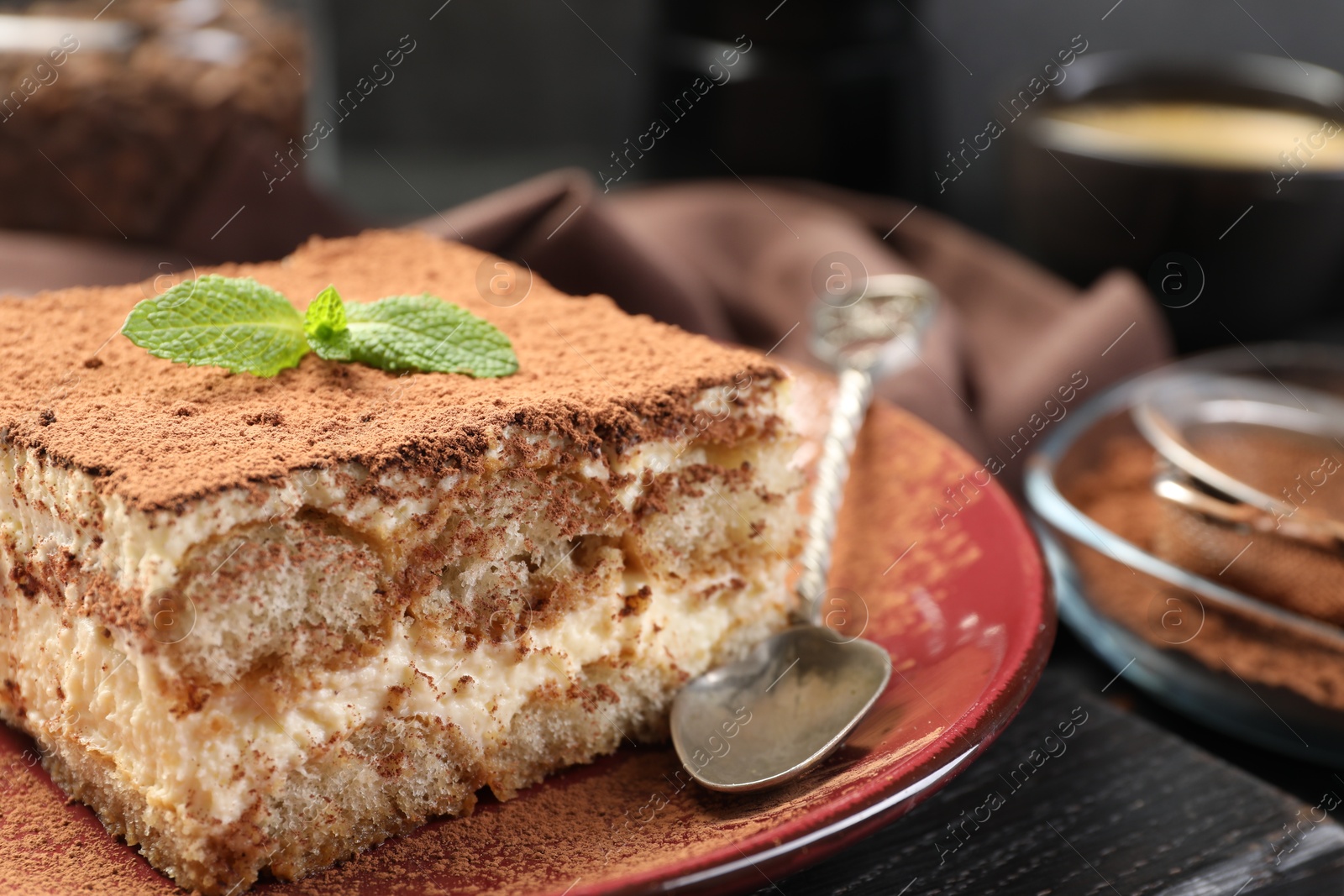 Photo of Delicious tiramisu with mint on table, closeup