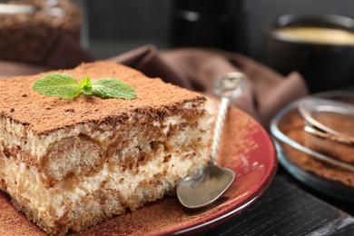 Photo of Delicious tiramisu with mint on table, closeup