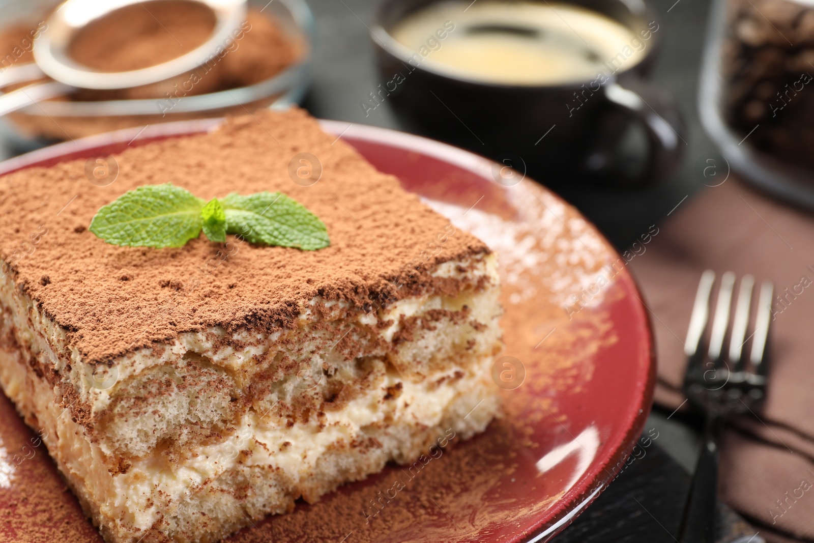 Photo of Delicious tiramisu with mint on dark table, closeup