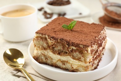 Photo of Delicious tiramisu with mint on light table, closeup