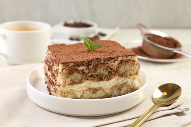 Photo of Delicious tiramisu with mint on light table, closeup