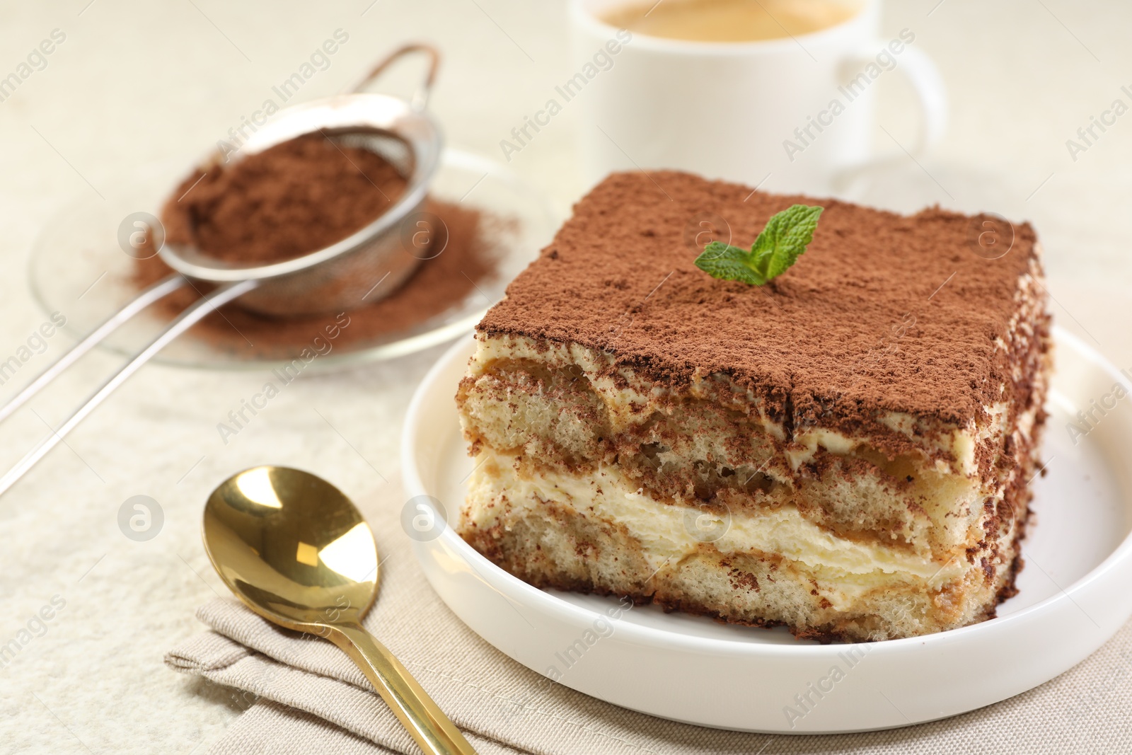 Photo of Delicious tiramisu with mint on light table, closeup