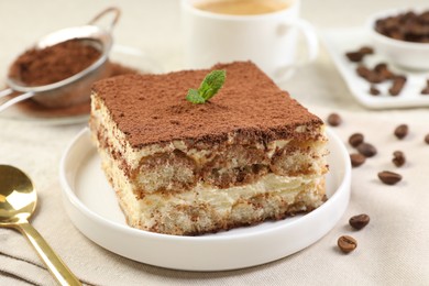 Photo of Delicious tiramisu with mint on light table, closeup