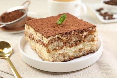 Photo of Delicious tiramisu with mint on light table, closeup