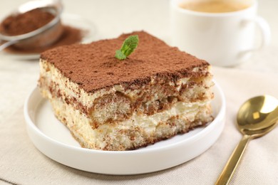 Photo of Delicious tiramisu with mint on light table, closeup