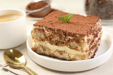 Photo of Delicious tiramisu with mint on light table, closeup