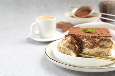 Photo of Delicious tiramisu with mint on light table, closeup. Space for text