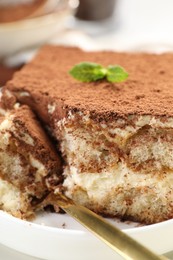 Photo of Delicious tiramisu with mint on plate, closeup