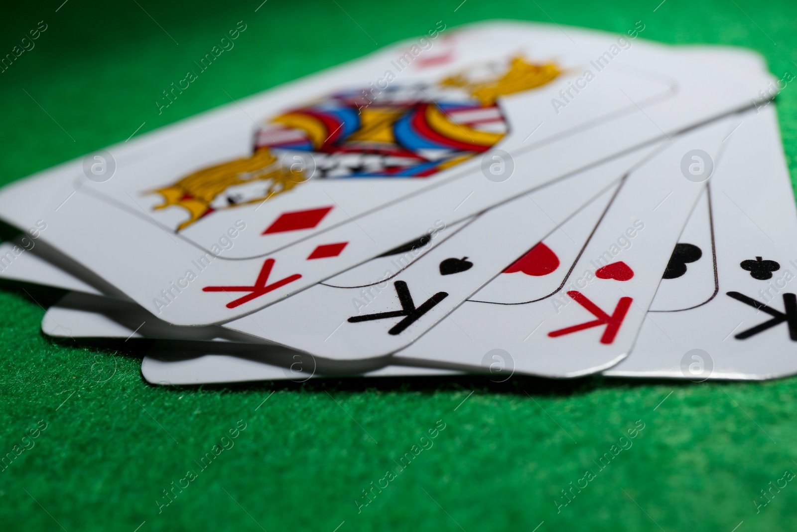 Photo of Poker game. Playing cards on green table, closeup