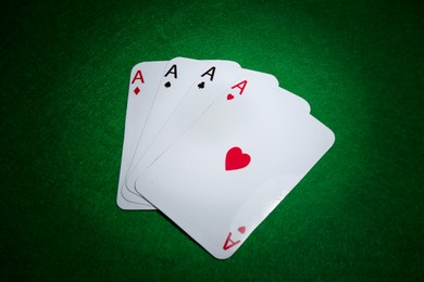 Poker game. Playing cards on green table, flat lay