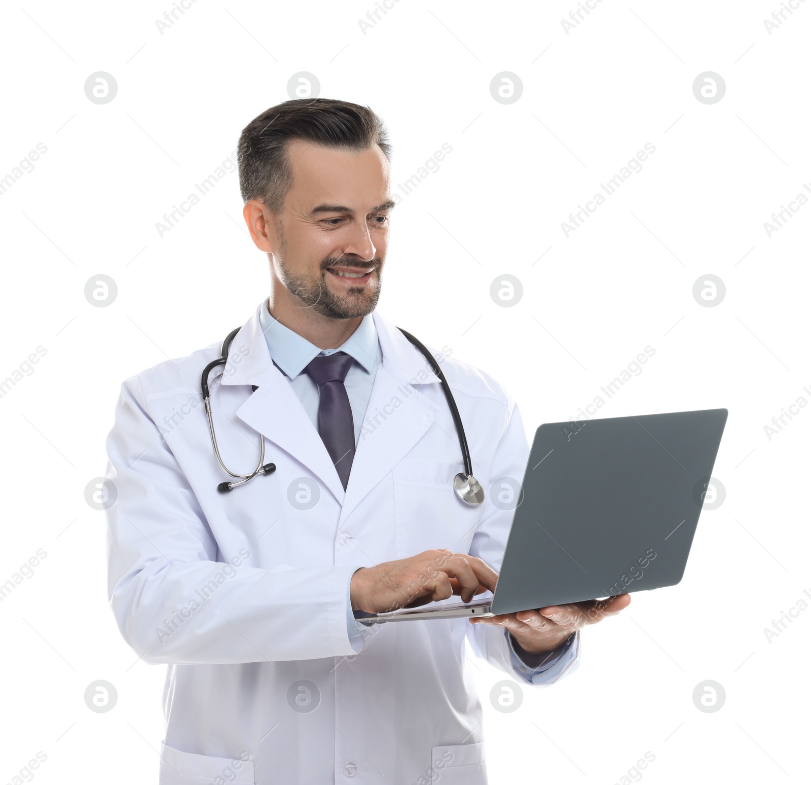 Photo of Smiling doctor with stethoscope using laptop on white background