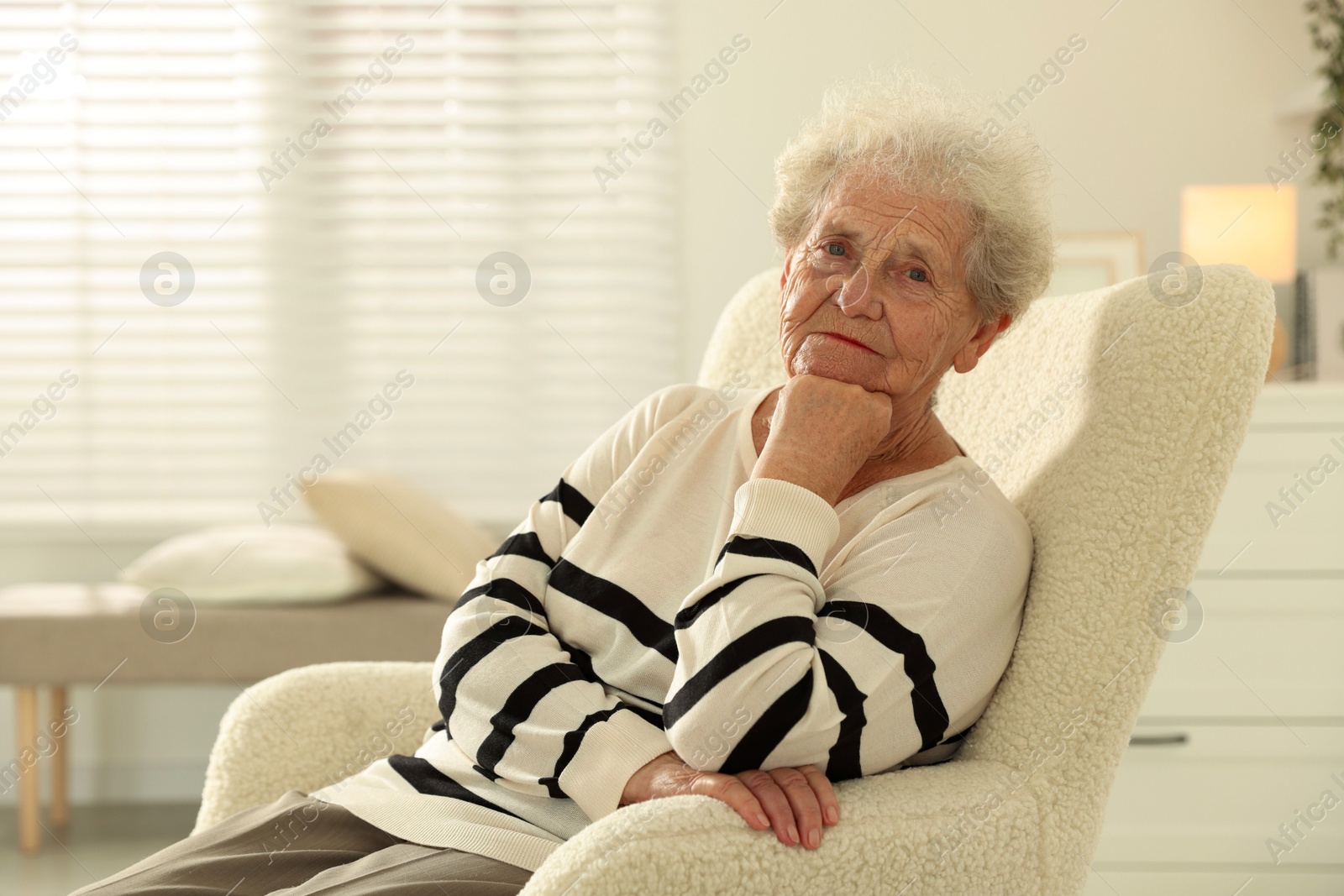 Photo of Beautiful senior woman sitting on armchair at home