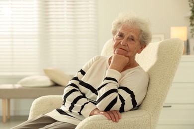 Photo of Beautiful senior woman sitting on armchair at home