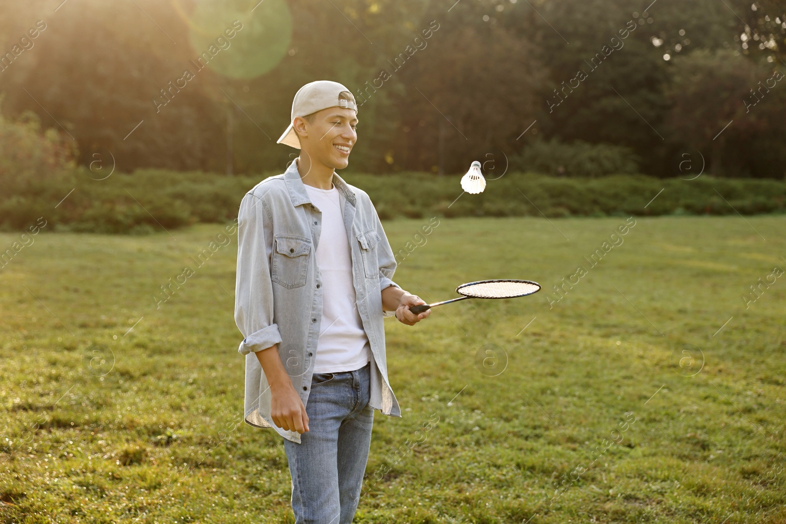 Photo of Young man playing badminton racket in park on sunny day