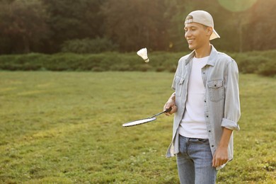 Photo of Young man playing badminton racket in park on sunny day