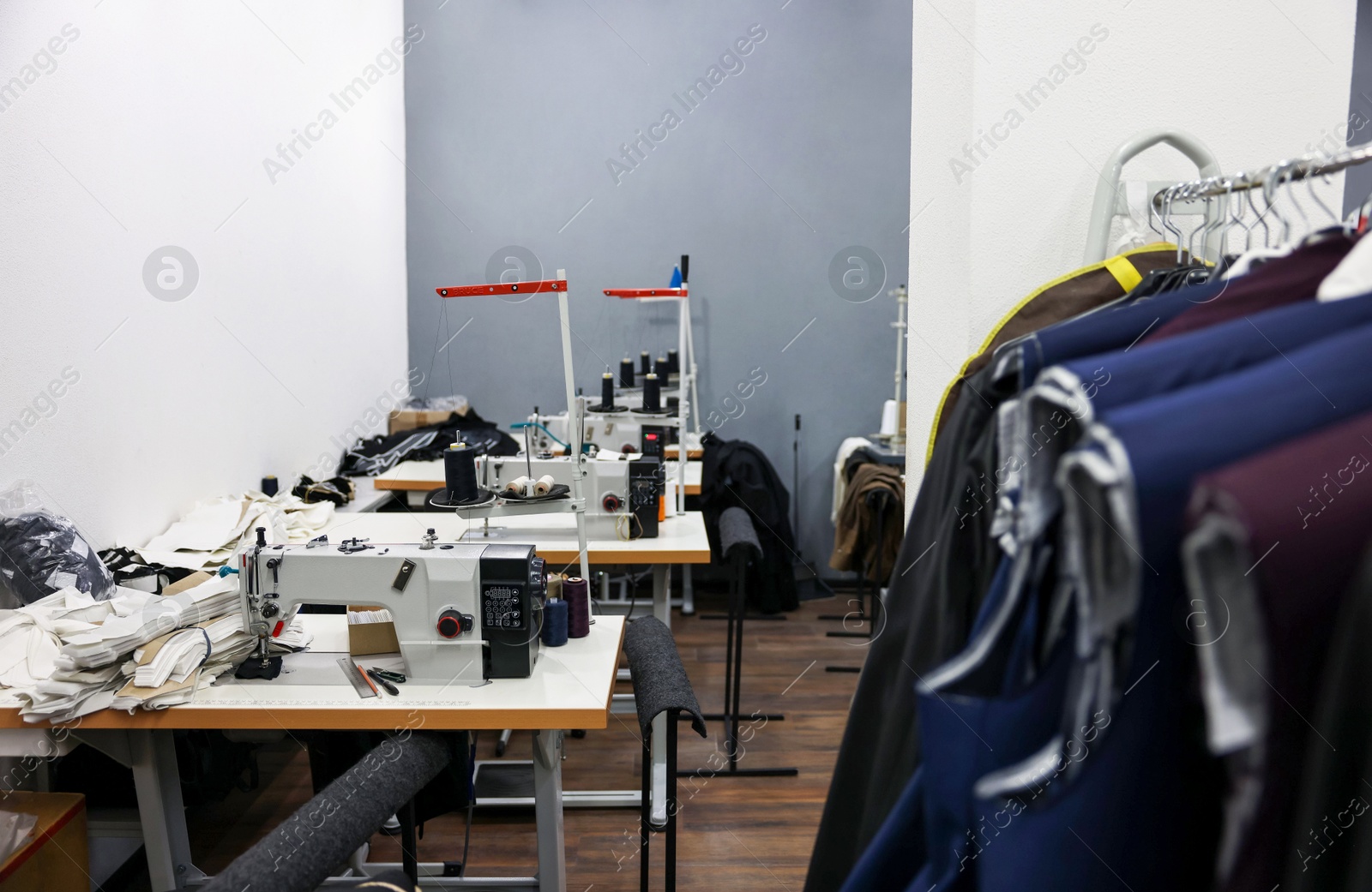 Photo of Sewing machines with spools of thread in professional workshop