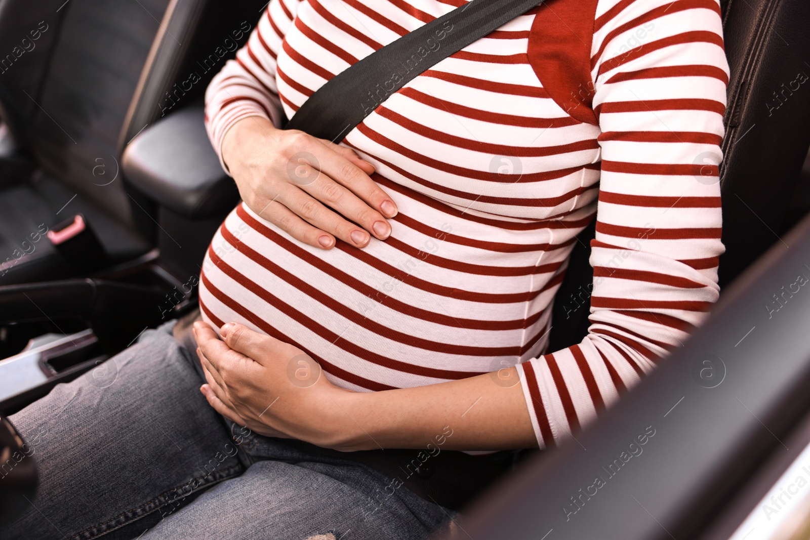 Photo of Pregnant woman with safety belt in car, closeup