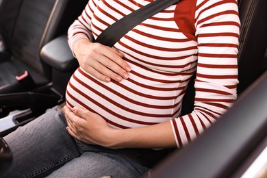 Pregnant woman with safety belt in car, closeup