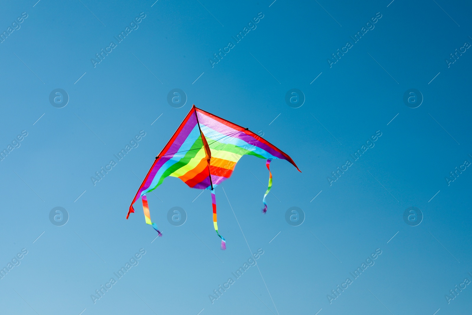 One colorful kite flying in blue sky Photo of One colorful kite flying in blue sky