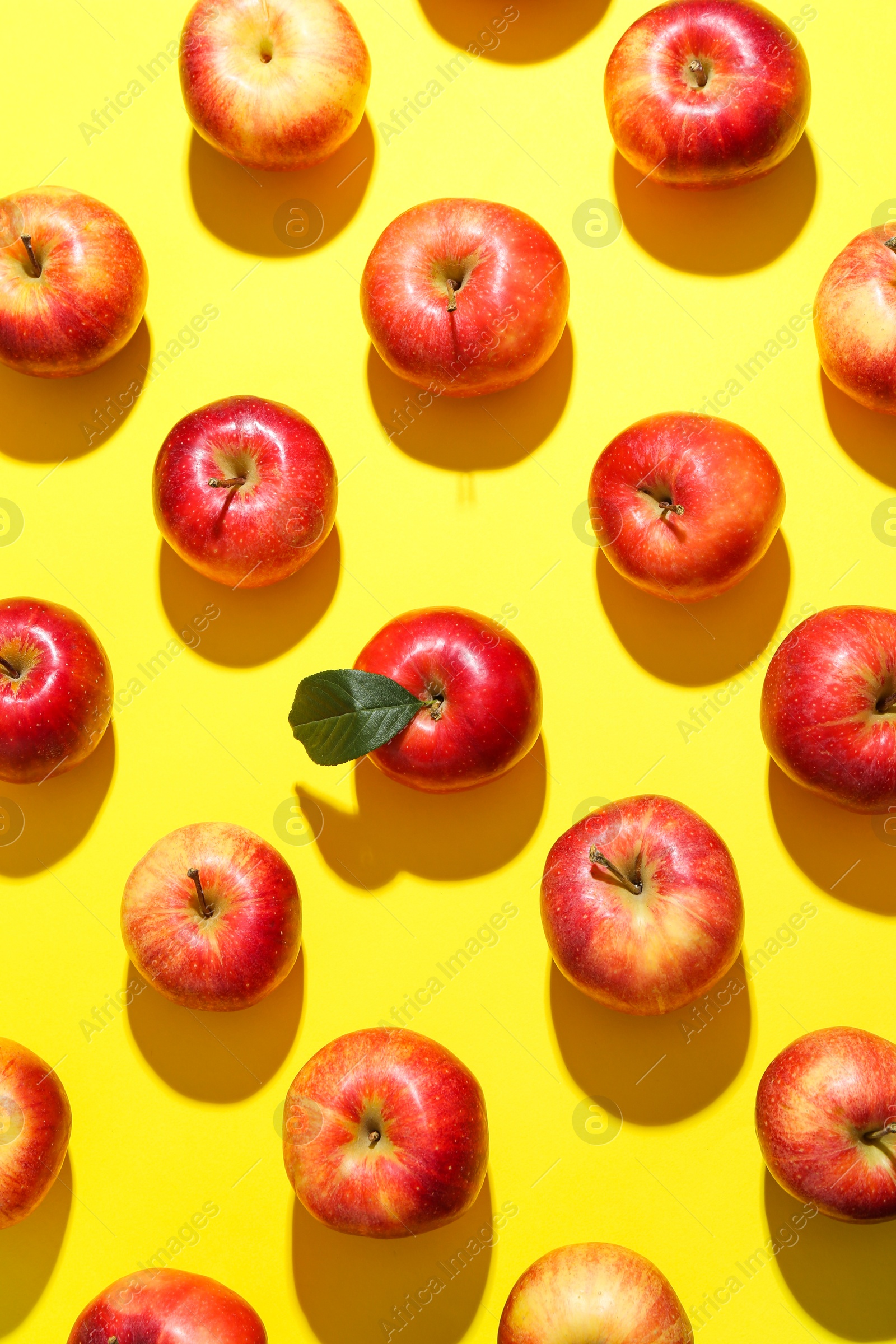 Photo of Flat lay composition with many red apples on yellow background