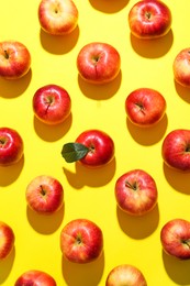 Flat lay composition with many red apples on yellow background