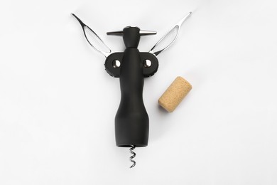 Wing corkscrew and cork on white background, top view