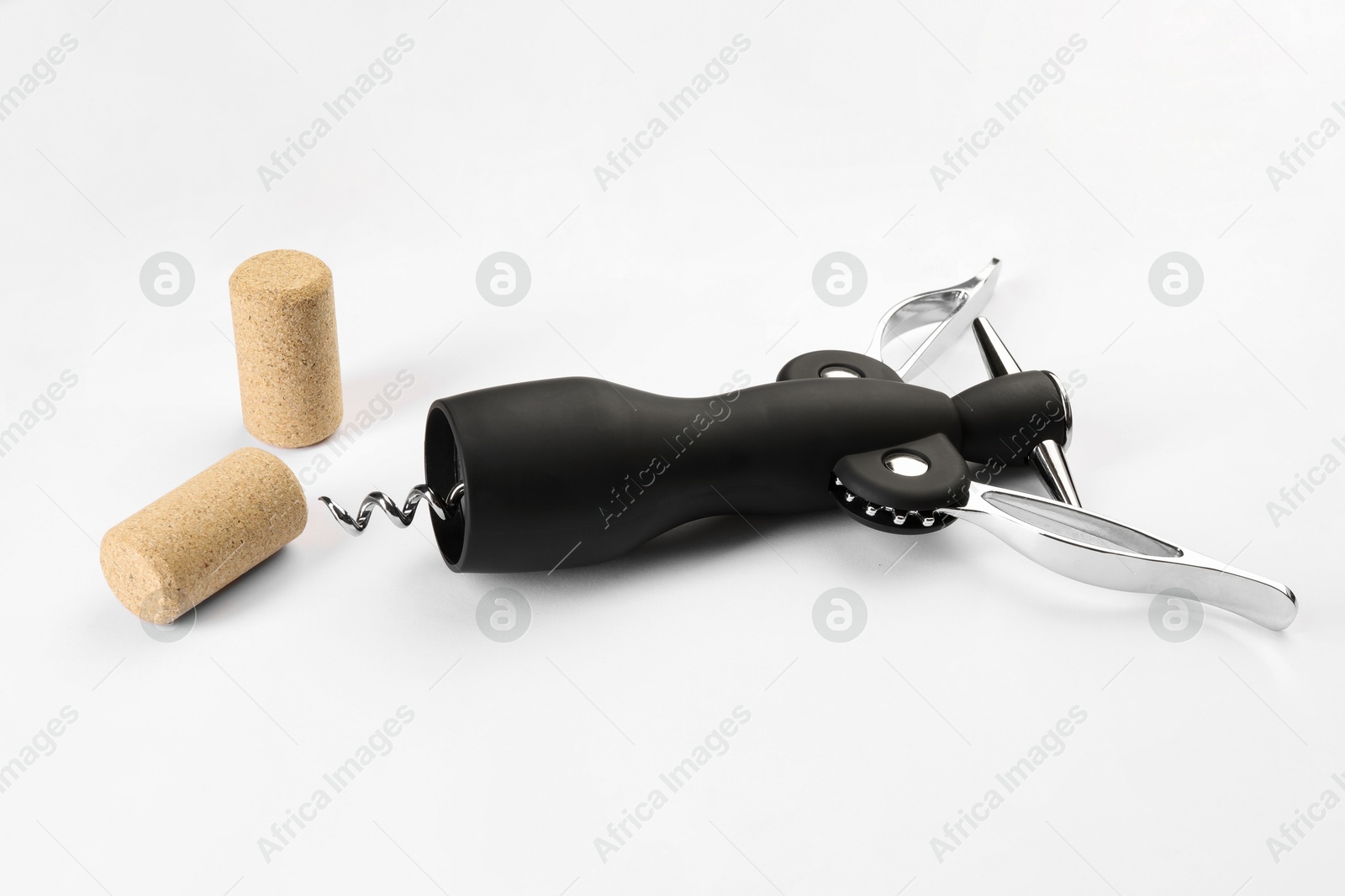 Photo of Wing corkscrew and corks on white background