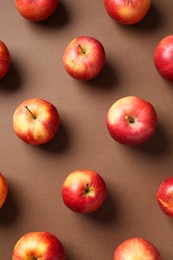 Photo of Ripe red apples on brown background, flat lay