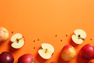 Photo of Fresh red apples and seeds on orange background, flat lay. Space for text