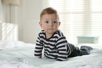 Photo of Cute little baby on bed at home, space for text