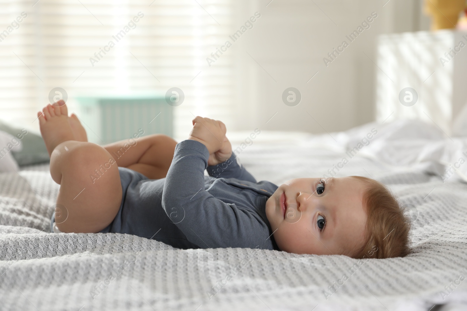 Photo of Cute little baby on bed at home