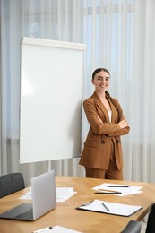 Photo of Happy woman near flip chart in office. Mockup for design