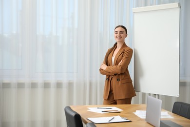 Photo of Happy woman near flip chart in office. Mockup for design