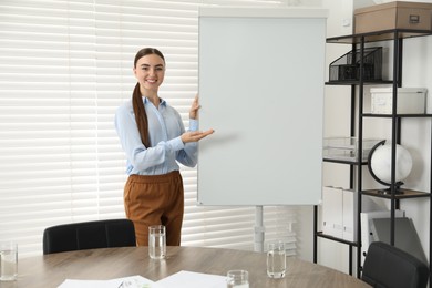 Happy woman near flip chart in office. Mockup for design