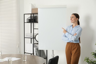 Happy woman near flip chart in office. Mockup for design