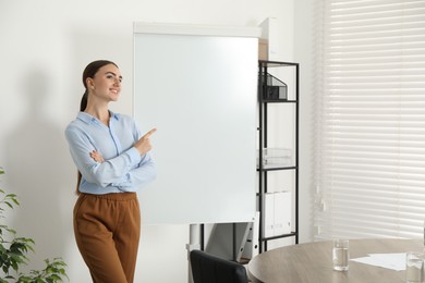 Photo of Happy woman near flip chart in office. Mockup for design