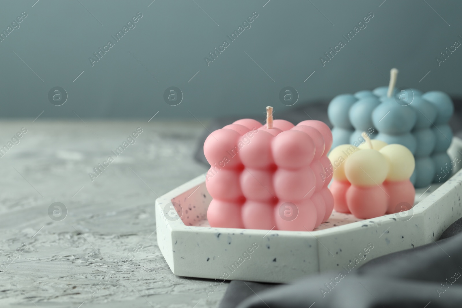 Photo of Beautiful bubble candles on grey table, closeup. Space for text