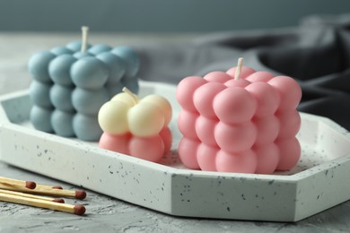 Photo of Beautiful bubble candles and matches on grey table, closeup